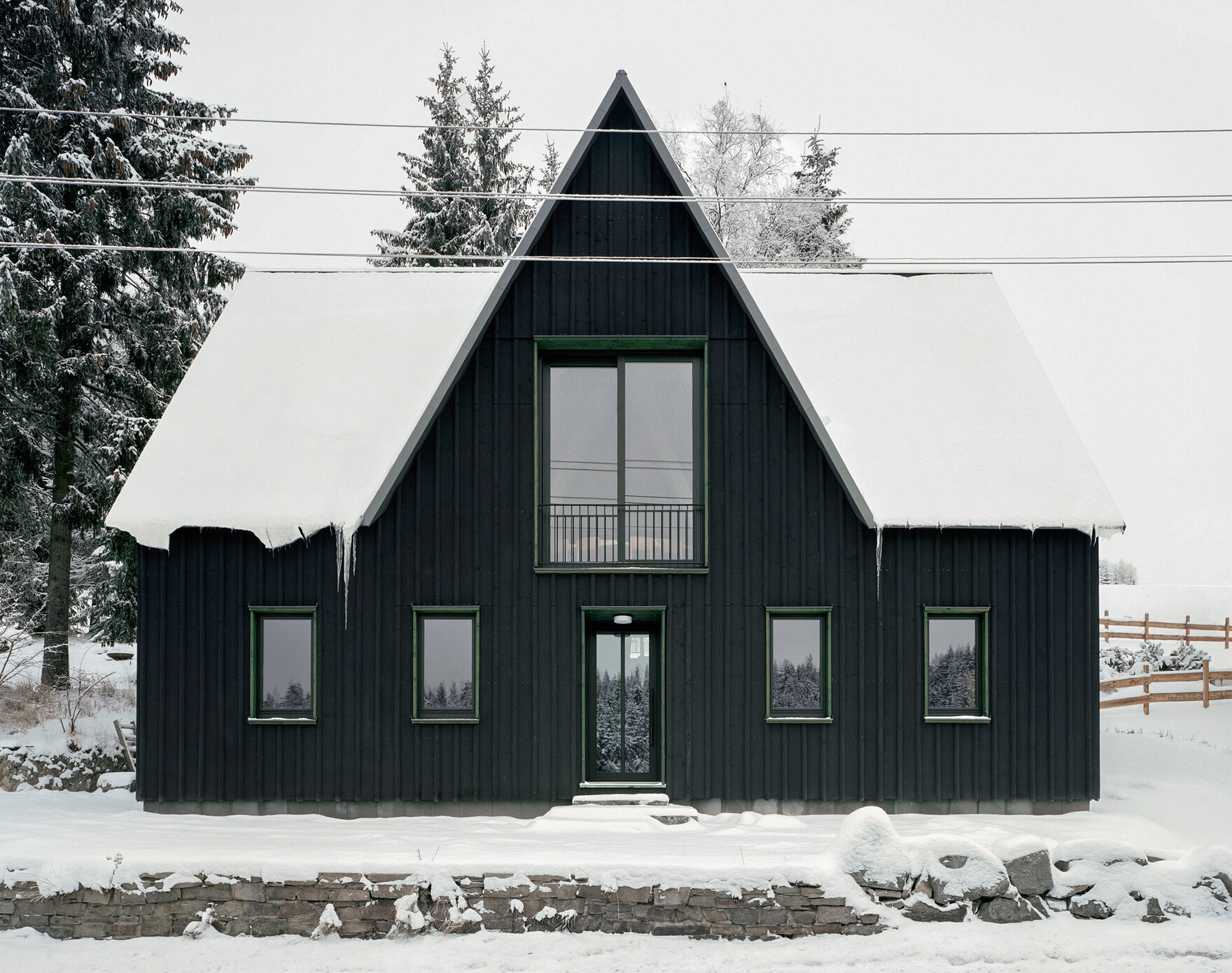 Schwarzes Gebäude mit großen Fenstern im Schnee